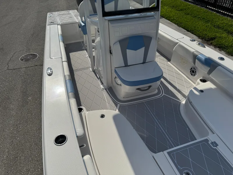 Slide: The Image of 2023 Robalo 246 Cayman boat interior with cushioned seating and spacious deck layout. - 39