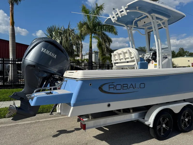 Slide: The Image of 2023 Robalo 246 Cayman boat with Yamaha engine on trailer, palm trees in background. - 4