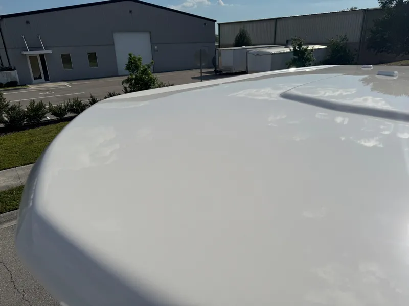 Slide: The Image of 2023 Robalo 246 Cayman boat deck in a sunny industrial setting. - 43