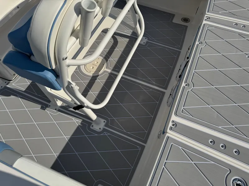 Slide: The Image of 2023 Robalo 246 Cayman boat deck with cushioned seating and rod holders. - 49