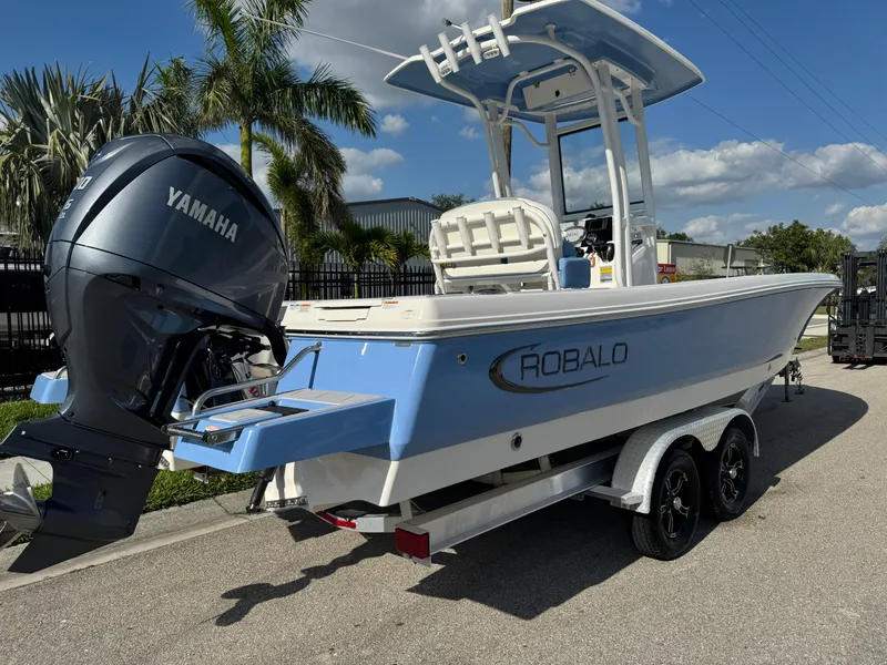 Slide: The Image of 2023 Robalo 246 Cayman boat with Yamaha engine on trailer, parked near palm trees. - 5