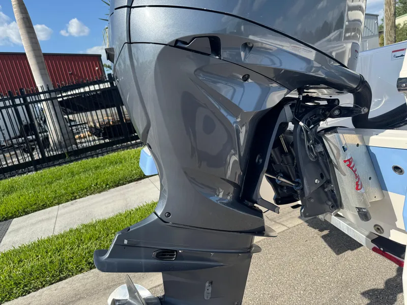 Slide: The Image of 2023 Robalo 246 Cayman outboard motor, parked on a sunny day near a fence. - 7