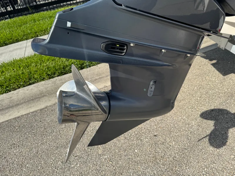 Slide: The Image of 2023 Robalo 246 Cayman boat propeller and lower unit on pavement. - 8
