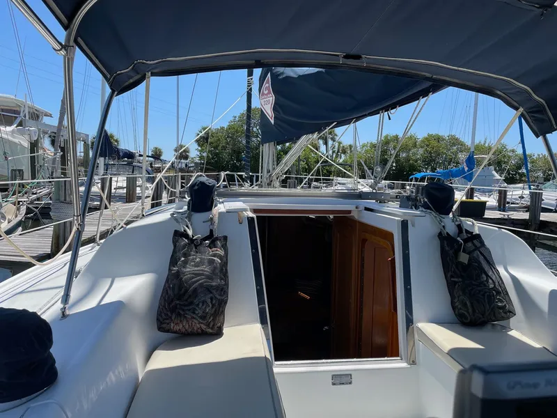 Slide: The Image of 1997 Catalina 320 sailboat cockpit with canopy, docked at marina. - 20