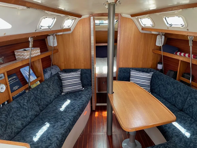 Slide: The Image of Interior of a 1997 Catalina 320 sailboat with cozy seating and wooden finishes. - 22