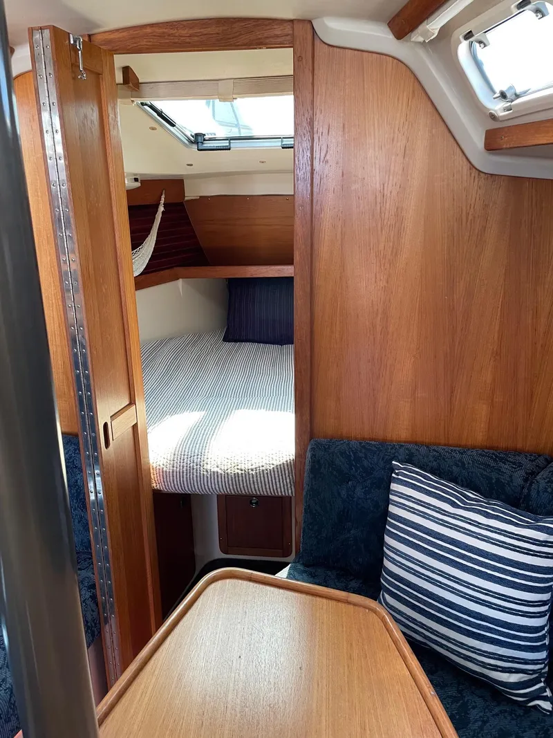 Slide: The Image of Interior of 1997 Catalina 320 sailboat with cozy cabin and wooden furnishings. - 25