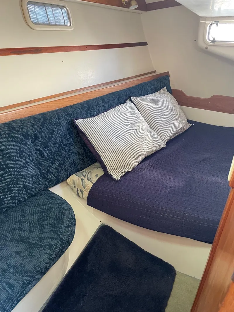 Slide: The Image of Interior cabin of a 1997 Catalina 320 sailboat with cozy bedding and cushions. - 26