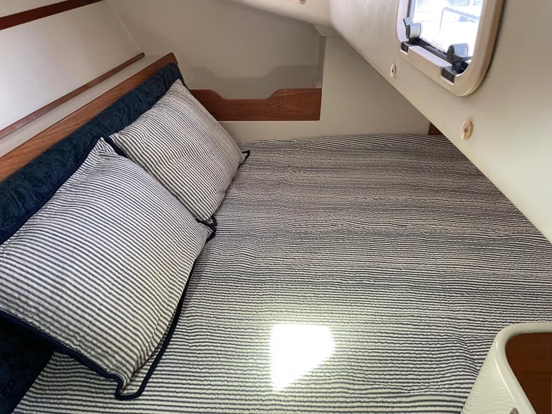 Slide: The Image of Cozy cabin interior of 1997 Catalina 320 sailboat with striped bedding and pillows. - 28
