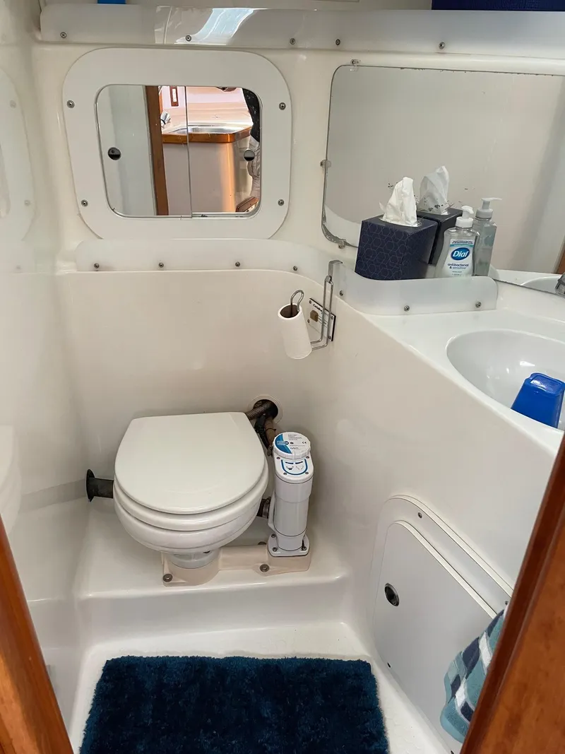 Slide: The Image of 1997 Catalina 320 yacht bathroom with toilet, sink, and mirror. - 29