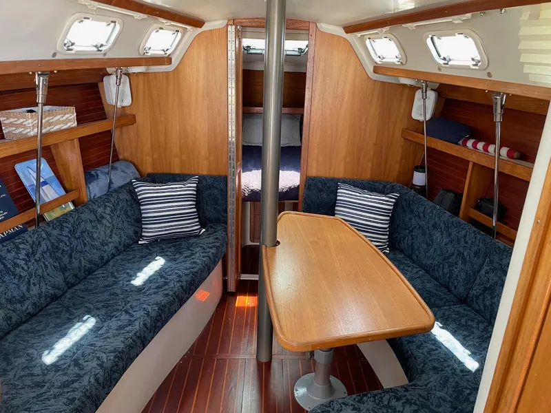 Slide: The Image of Interior of a 1997 Catalina 320 sailboat with cozy seating and wooden table. - 3