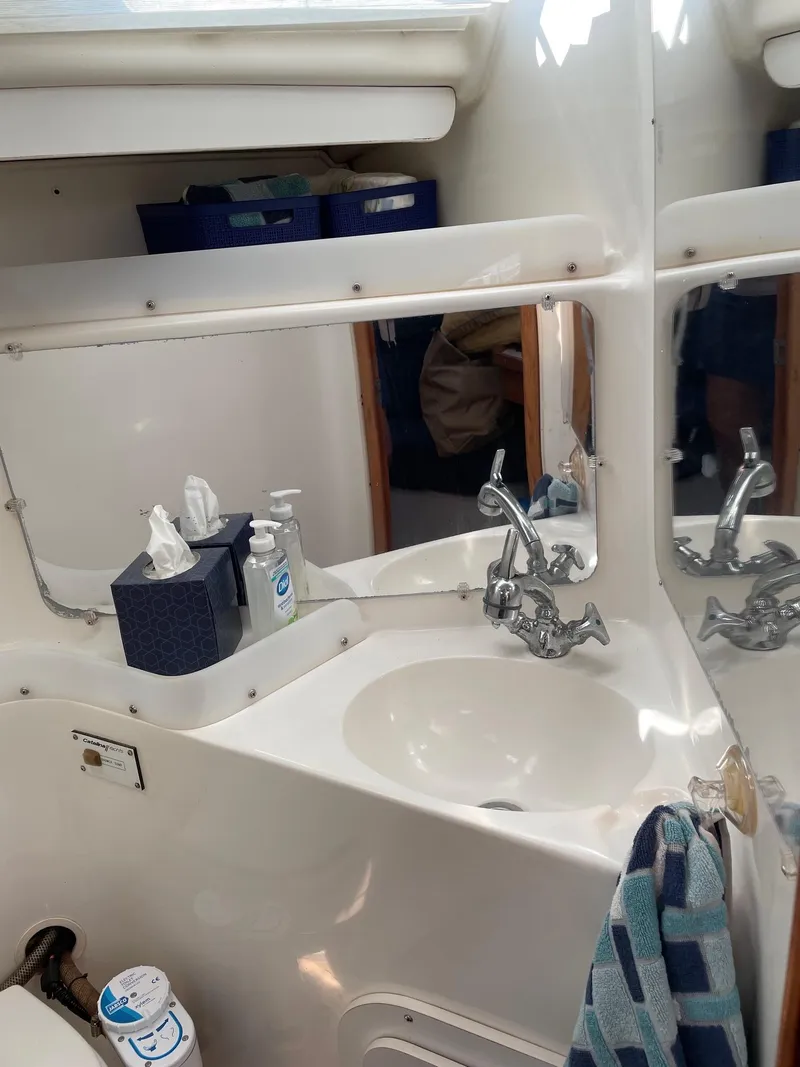 Slide: The Image of 1997 Catalina 320 yacht bathroom with sink, mirror, and toiletries. - 30