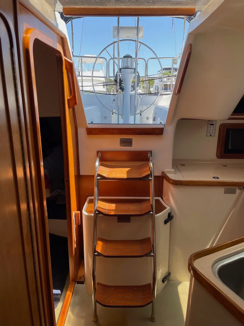Slide: The Image of Interior view of 1997 Catalina 320 sailboat with wooden steps and helm. - 31