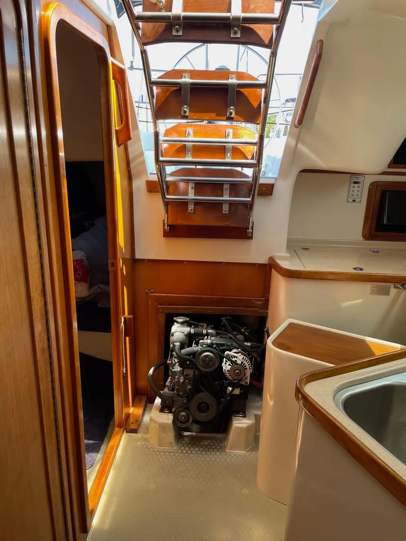 Slide: The Image of Interior of a 1997 Catalina 320 sailboat showing engine compartment and cabin details. - 32