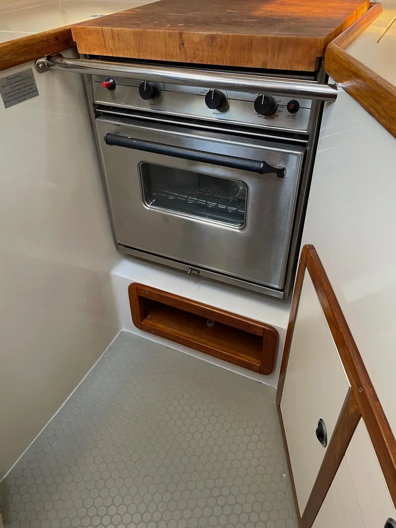 Slide: The Image of 1997 Catalina 320 yacht kitchen with stainless steel oven and wooden countertop. - 38