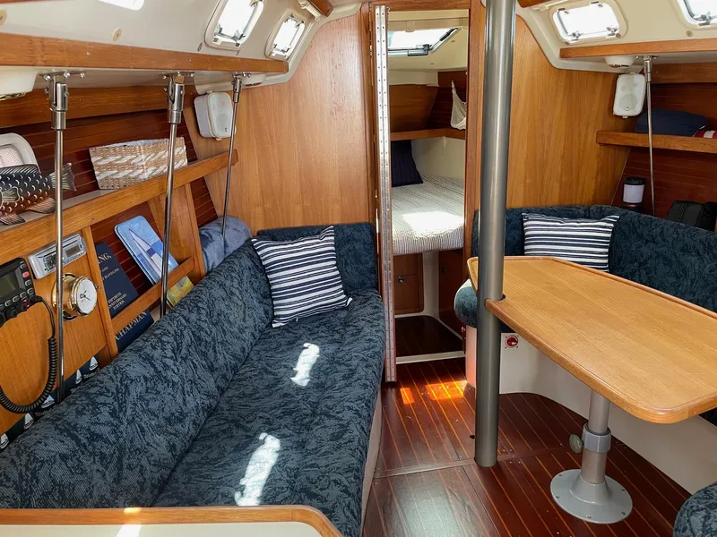 Slide: The Image of Interior of a 1997 Catalina 320 sailboat with cozy seating and wooden finishes. - 8