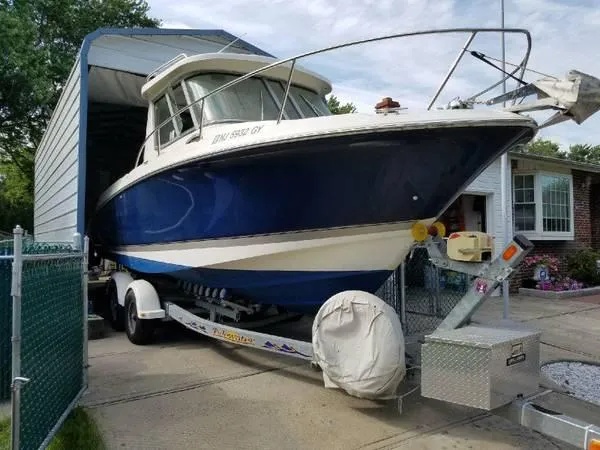 Slide: The Image of 2006 Wellcraft 252 Coastal boat on trailer, parked in driveway near a house. - 1