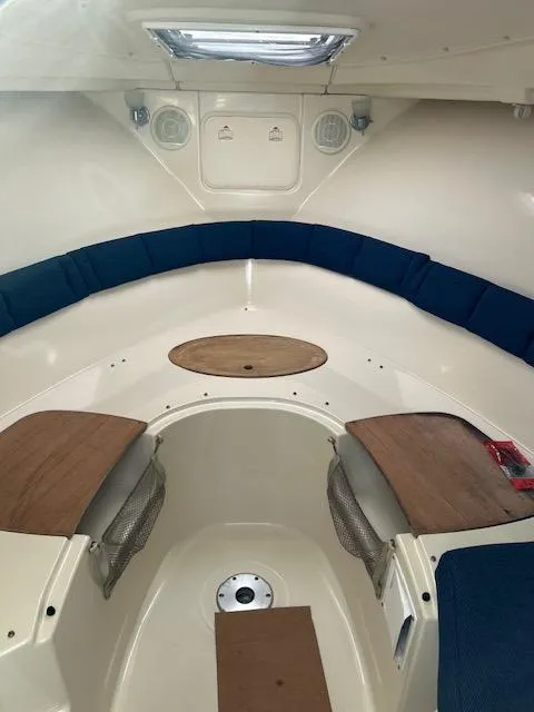 Slide: The Image of 2006 Wellcraft 252 Coastal boat interior with blue seating and wooden accents. - 11