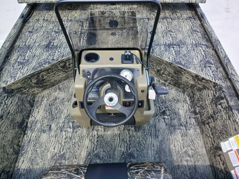 Slide: The Image of 2025 Tracker Grizzly 2072 CC Sportsman boat console with camouflage design and steering wheel. - 4