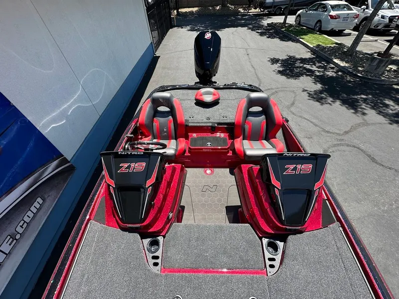 Slide: The Image of 2025 Nitro Z19 Pro boat interior with red and black seating, parked outdoors. - 12