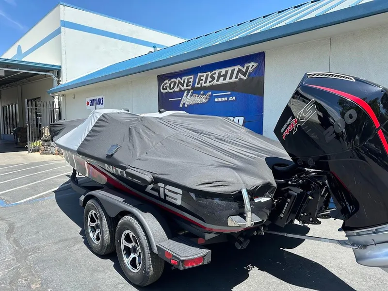 Slide: The Image of 2025 Nitro Z19 Pro boat covered, parked outside a fishing store. - 36