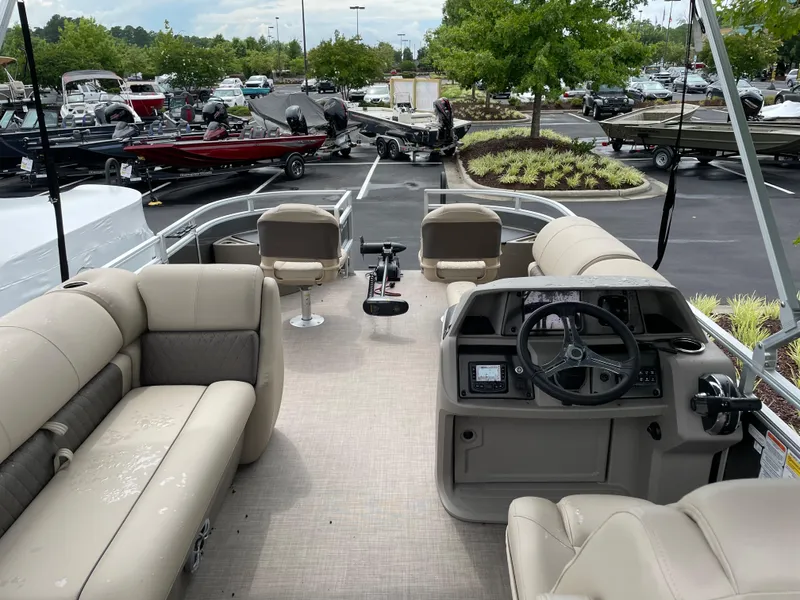 Slide: The Image of 2025 Sun Tracker Fishin' Barge 20 DLX pontoon boat interior with seating and steering console. - 3