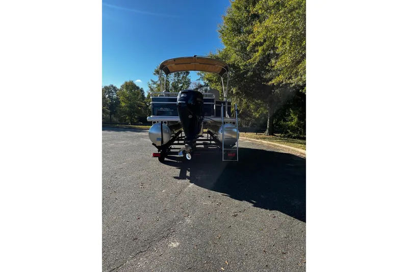 Slide: The Image of 2025 Sun Tracker Fishin' Barge 20 DLX pontoon boat parked on a sunny day. - 3