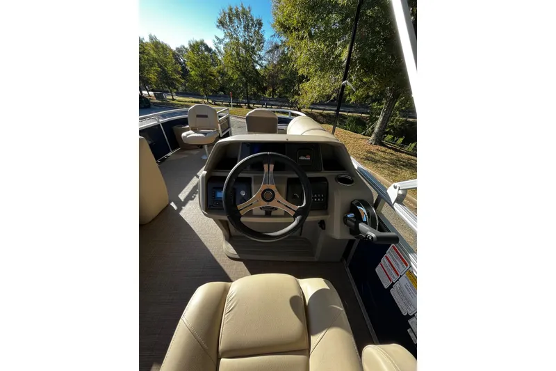 Slide: The Image of 2025 Sun Tracker Fishin' Barge 20 DLX interior with steering wheel and seating. - 5