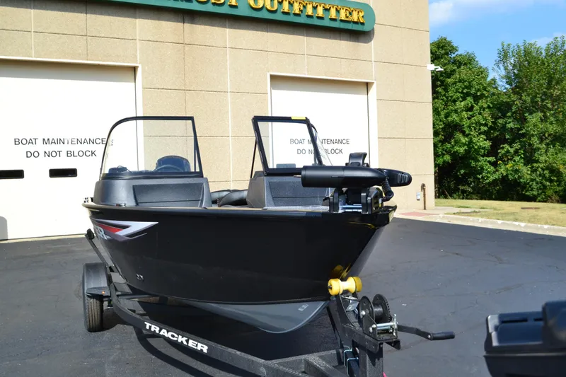 Slide: The Image of 2025 Tracker Pro Guide V-16 WT boat on trailer outside maintenance facility. - 2