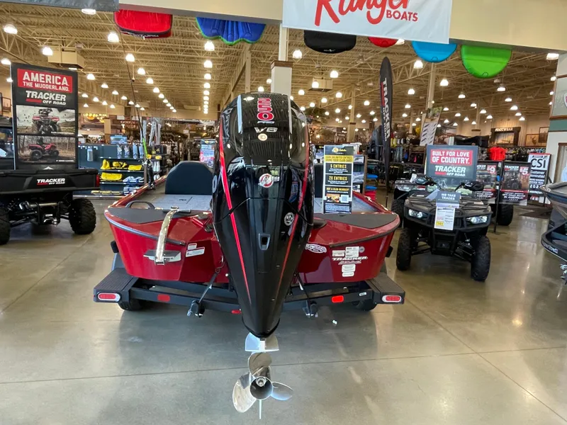 Slide: The Image of 2025 Tracker Savage 215 boat displayed in a showroom with promotional banners. - 3