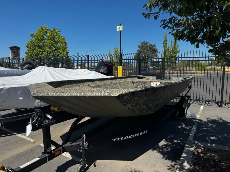 The Image of 2025 Tracker GRIZZLY 2072 Utility boat on trailer in parking lot, sunny day. - 0