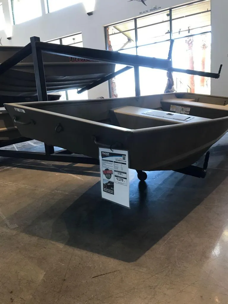 Slide: The Image of 2025 Tracker Grizzly 15 Jon boat displayed indoors on a stand. - 3