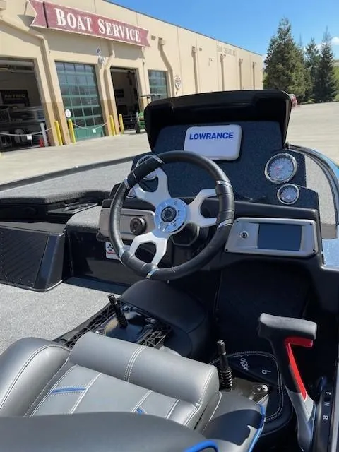 Slide: The Image of 2024 Nitro Z20 boat cockpit with steering wheel and Lowrance electronics, outside a boat service shop. - 4