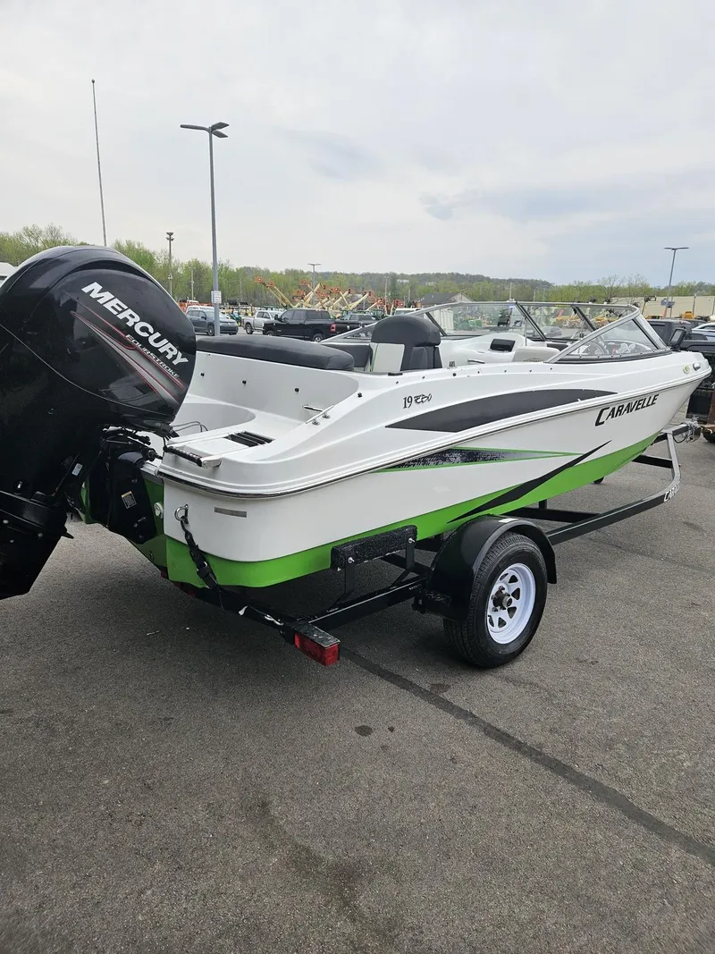 Slide: The Image of 2015 Caravelle 19EBo boat with Mercury engine on trailer, parked outdoors. - 1