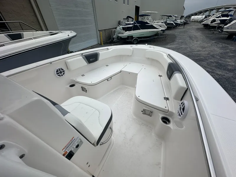 Slide: The Image of 2023 Robalo R200 Center Console boat interior with seating and storage, displayed in a marina. - 13