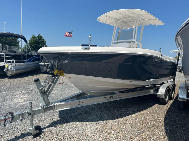 Slide: The Image of 2023 Robalo R200 Center Console boat on trailer, parked outdoors under clear blue sky. - 18