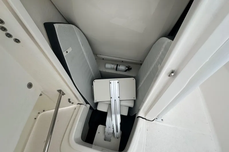 Slide: The Image of 2023 Robalo R200 Center Console interior storage with seating and fire extinguisher. - 25