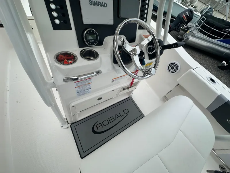 Slide: The Image of 2023 Robalo R200 Center Console boat interior with steering wheel and Simrad display. - 4