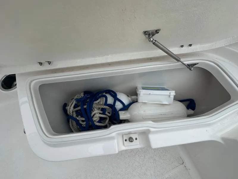 Slide: The Image of Storage compartment of 2023 Robalo R200 Center Console with ropes and equipment. - 8