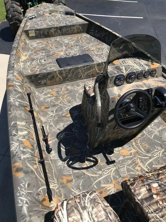 Slide: The Image of 2025 War Eagle Blackhawk 961 boat with camouflage design and steering console. - 6