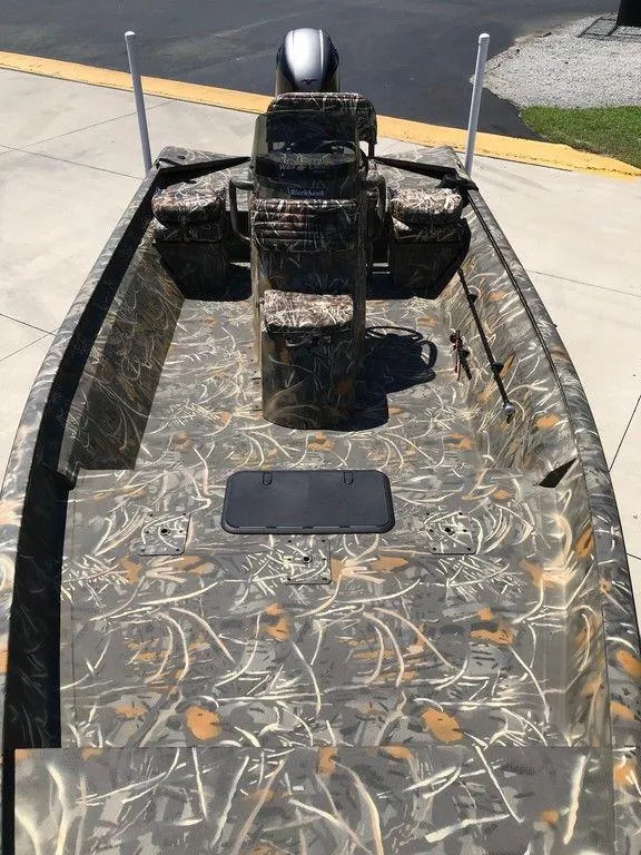Slide: The Image of 2025 War Eagle Blackhawk 961 boat with camouflage design, parked on concrete. - 8