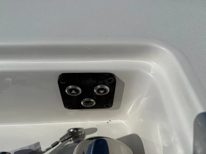Slide: The Image of Control panel on 2025 Key West 260 CC boat, featuring three buttons in a white compartment. - 11
