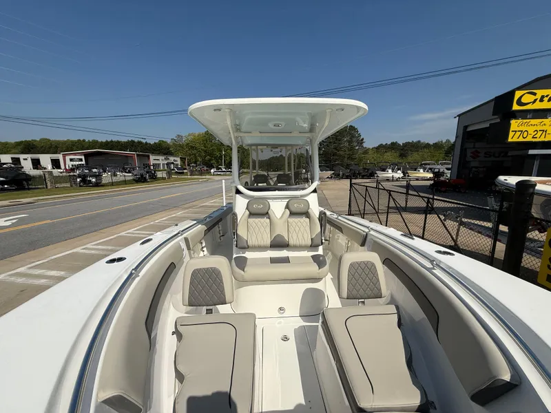 Slide: The Image of 2025 Key West 260 CC boat with spacious seating and modern design, parked outdoors. - 13