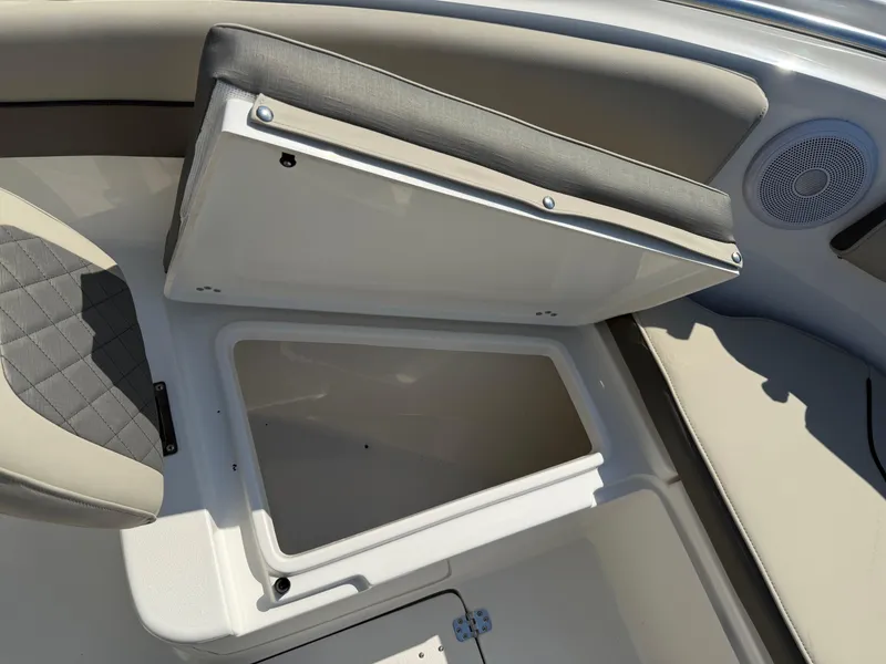 Slide: The Image of 2025 Key West 260 CC boat storage compartment with cushioned seat and speaker. - 18