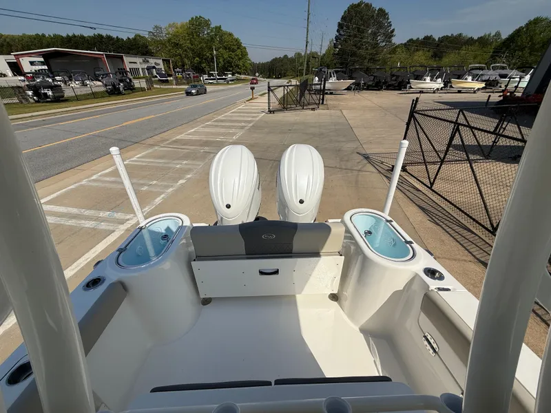 Slide: The Image of 2025 Key West 260 CC boat with dual engines, parked near a road and dealership. - 31