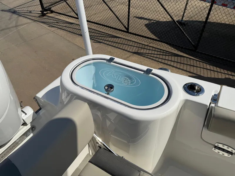 Slide: The Image of 2025 Key West 260 CC boat livewell with seating, docked near a fence. - 34