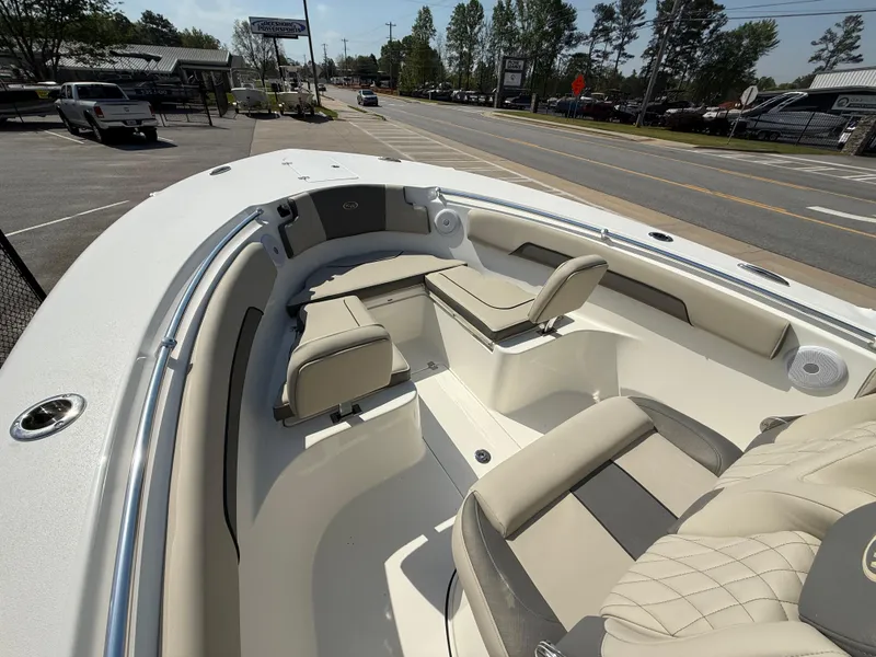 Slide: The Image of 2025 Key West 260 CC boat interior with beige seating, parked near a road. - 9