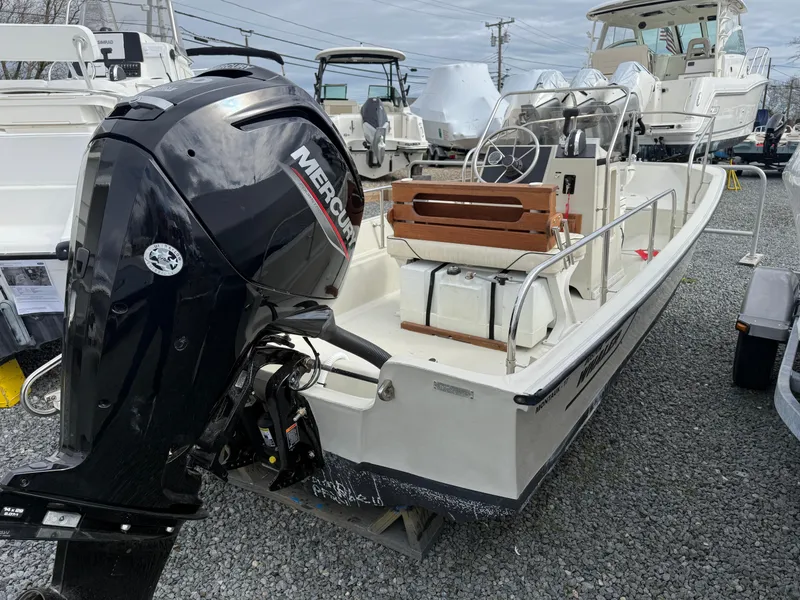Slide: The Image of 1993 Boston Whaler Montauk 17 CC boat with Mercury outboard motor, displayed in a marina. - 3