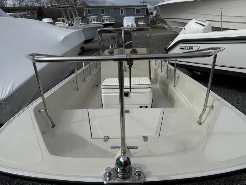 Slide: The Image of 1993 Boston Whaler Montauk 17 CC boat, docked, showcasing open deck and seating. - 4