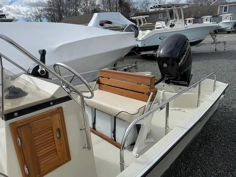 Slide: The Image of 1993 Boston Whaler Montauk 17 CC boat with wooden bench and outboard motor. - 8