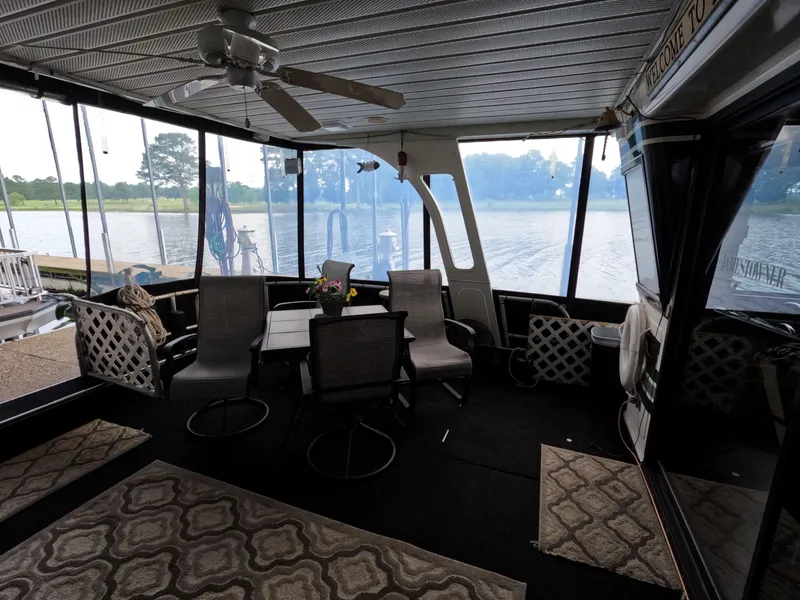 Slide: The Image of Houseboat interior with seating area, ceiling fan, and lake view. Jamestowner 1667WB Americana Custom, 1998. - 20